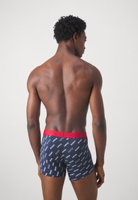 Marinblå kalsonger med röd elastisk midja, med upprepade "Levi's"-logotyper i vitt, i bomullstyg, tajt passform, kort ben-design.