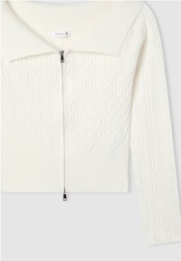 Biały kardigan w splot warkoczowy z prążkowanym kołnierzem i dolnym wykończeniem, z przednim zamkiem błyskawicznym. Teksturowany wzór z długimi rękawami i krótkim krojem.