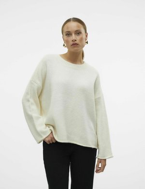 Cream-colored knit sweater with a relaxed fit, ribbed round neckline, and long sleeves. Paired with black pants. Soft texture.