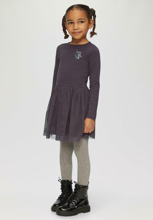 Robe à manches longues de couleur violet foncé avec une jupe en tulle, ornée d'un motif de licorne. Associée à des leggings gris et des bottes noires à lacets.