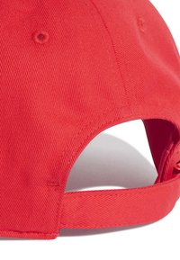 Červená čepice s texturovanou bavlněnou tkaninou, zakřiveným kšiltem a nastavitelným popruhem na zadní straně pro bezpečné nošení.