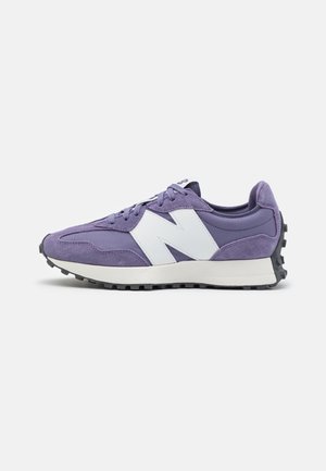 Baskets New Balance violettes et blanches avec semelle en caoutchouc et bande de roulement texturée, vues de côté sur un fond clair uni.