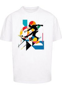 Hvid t-shirt med en dynamisk grafik af en sort atlet, omgivet af farverige geometriske former i gul, rød og blå.