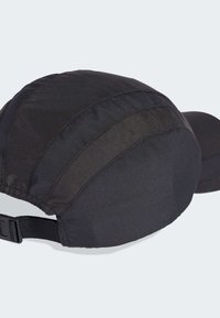 Crna kapa od teksturiranog tkanja s okruglom krunom i čvrstim obodom. Ima podesivi remen straga.