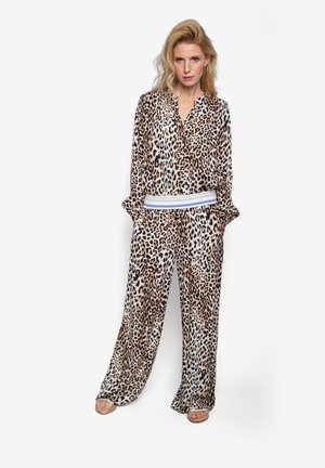 Jedwabny komplet piżamowy w panterkę z długimi rękawami i spodniami o szerokich nogawkach. Z białą elastyczną talią z niebieskimi paskami.