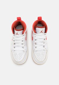 Sneaker da basket bianche alte con accenti rossi, dotate di punta perforata, lacci bianchi e rivestimento interno texture.