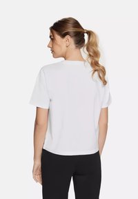 Witte T-shirt met korte mouwen en een ronde hals, gemaakt van zacht katoen, met een relaxed fit en rechte onderrand, weergegeven vanaf de achterkant.