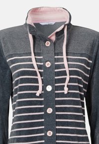 Huvtröja med grå och rosa randig design, knäppning framtill och dragsnöre i halsen. Mjuk tyg med en slät yta.