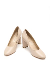 Beżowe buty na obcasie z gładkiej skóry, z zaokrąglonym noskiem i solidnym słupkowym obcasem, z subtelnym logo na wkładce.