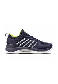 Zapatilla deportiva azul oscuro con acentos de rayas blancas, parte superior texturizada, cuello verde neón y suela acolchada. Diseño ligero y transpirable.