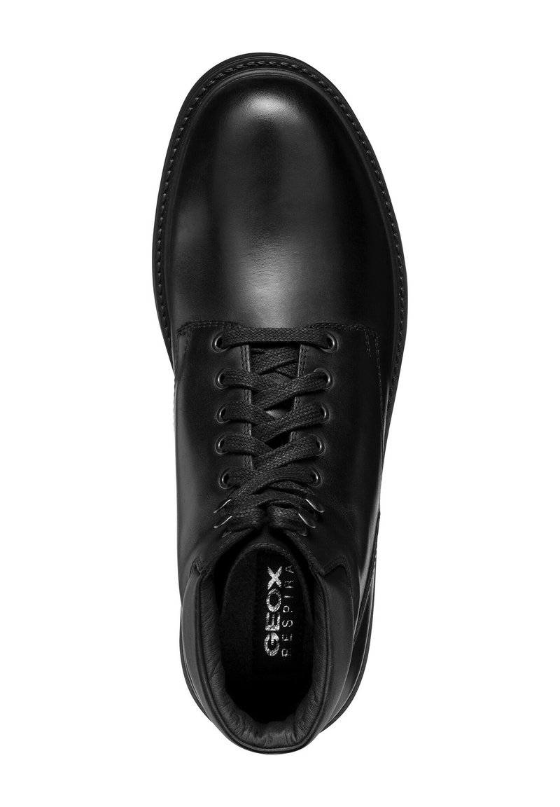 Schwarzer Lederschuh mit glatter Oberfläche, runder Zehenform und Schnürdesign. Das Innere verfügt über gepolsterte Polsterung für zusätzlichen Komfort.