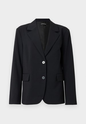 Zwarte op maat gemaakte blazer met inkeping revers, twee knopen aan de voorkant, klepzakken en lange mouwen tegen een effen lichte achtergrond.