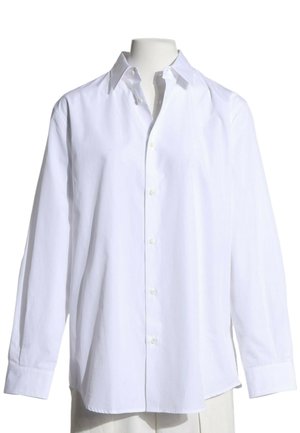 Camisa blanca de manga larga con botones y cuello, mostrada en un maniquí sin cabeza sobre un fondo blanco.