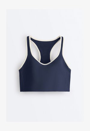 Reggiseno sportivo blu navy con bordatura bianca, design con schiena a vogatore e spalline larghe, disteso su uno sfondo bianco.