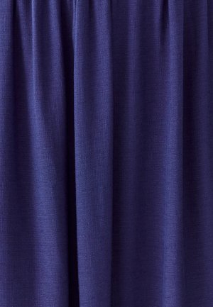 Tenda blu navy realizzata in tessuto testurizzato, con pieghe nella parte superiore, che si drappeggia morbidamente con una leggera lucentezza.
