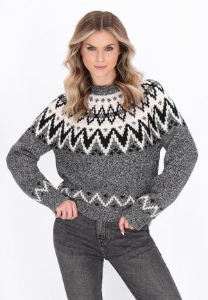 Maglione grigio lavorato a maglia con motivi geometrici in bianco e nero, dotato di scollatura tonda e polsini e orlo a coste. Il filato texturizzato aggiunge profondità.