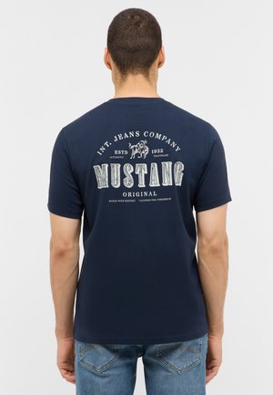 Marineblaue Baumwoll-T-Shirt mit einem Vintage-Graphikdruck auf der Rückseite, der den Text "MUSTANG" in Weiß und Hellgrau zeigt. Mit kurzen Ärmeln.