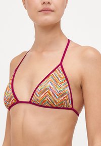 Bikini-top met een kleurrijk visgraatpatroon in oranje, roze, groen en paars; afgewerkt met bordeauxrood; verstelbare bandjes.