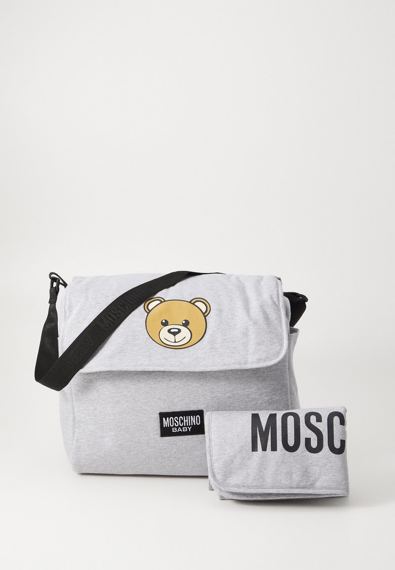 Grey messenger bag with bear graphic, black strap, and Moschino Baby logo. Includes matching changing mat in grey with black text.
