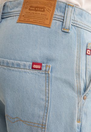Jasnoniebieskie dżinsy o kroju z brązową skórzaną metką z napisem "BIG STAR" i czerwonymi akcentami logo. Do ich cech należą przeszycia i kieszenie.
