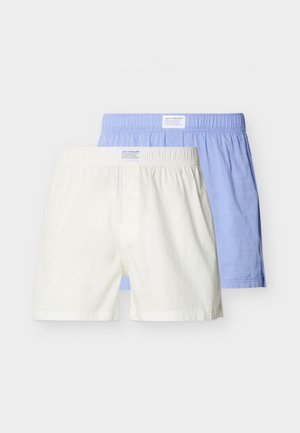 Zwei Herrenboxershorts aus Baumwolle, ein Paar weiß und ein Paar hellblau, frontseitig dargestellt mit elastischen Bündchen und kleinen Levi Strauss Etiketten.