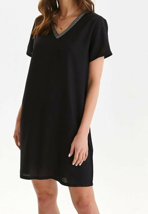 Mustat lyhythihaiset mekot, joissa on V-pääntie ja kuvioitu reunus kaula-aukossa. Kevyt kangas, löysä malli ja polven ylle ulottuva pituus.