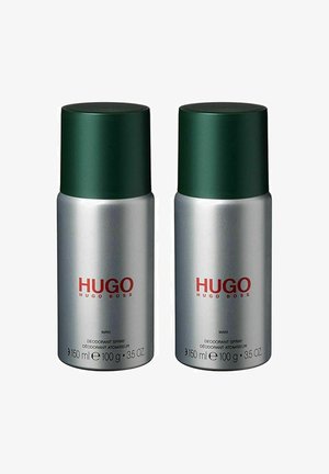 To cylinderformenede deodorant sprays med sølvfarvede kroppe, grønne hætte og rød tekst, der står "HUGO" og "MAN." Hver dåse indeholder 150 ml.