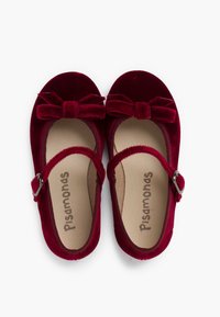 Rote Samt-Mary-Jane-Schuhe verfügen über einen Schnallenriemen, eine abgerundete Spitze und eine dekorative Schleife an der Vorderseite. Weiche Innenauskleidung mit Logo.
