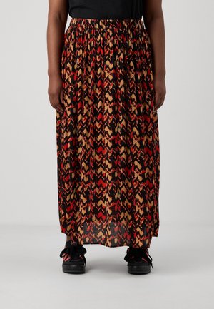 Person wearing a red, beige, and black patterned long skirt with elastic waist and black sneakers against a plain light background.