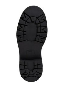 Semelle de chaussure en caoutchouc noir présentant un motif de semelle détaillé pour une meilleure traction, avec un logo embossé au centre. Finition lisse et conception robuste.