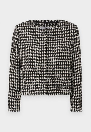 Veste à motif pied-de-poule noir et blanc avec un design cropped, un col encadré et des franges le long des bords. Comprend deux poches avant.