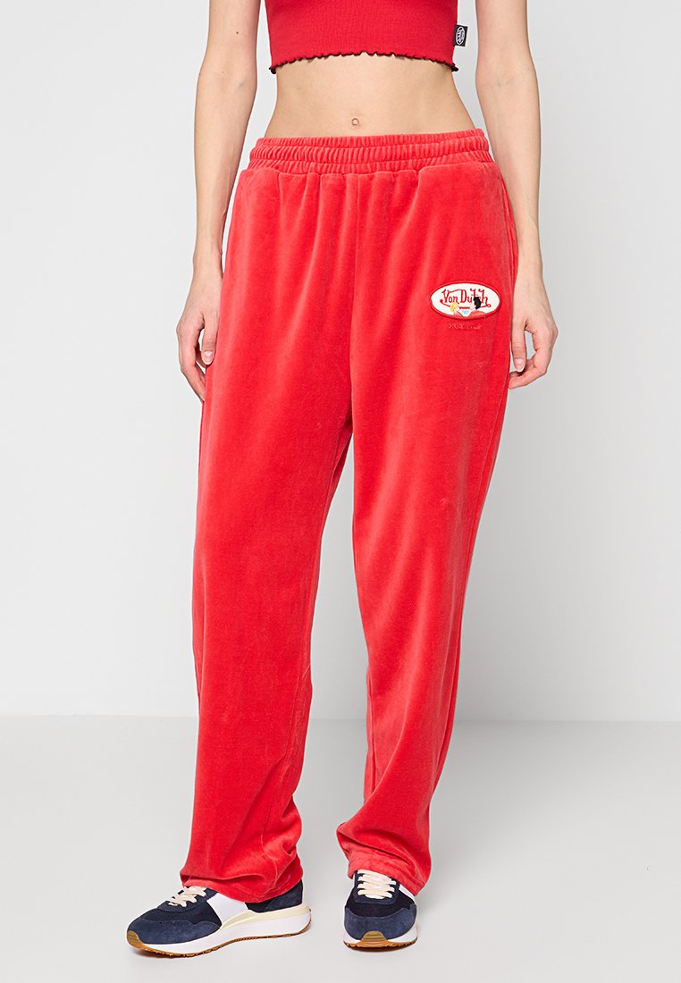 Rote Samt-Sweatpants mit einem elastischen Bund, ausgestattet mit einem runden, gestickten Logo-Patch. Lässiger Schnitt mit geraden Beinen.
