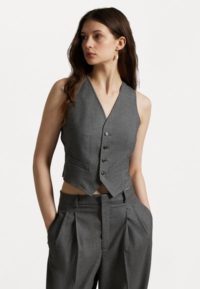 Vesta gri fără mâneci, cu decolteu în V, design ajustat, cinci nasturi, două buzunare frontale și un tiv scurt. Asortată cu pantaloni gri corespunzători.
