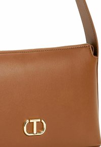 Borsa a tracolla in pelle marrone con texture liscia, caratterizzata da un accento in metallo dorato. Design semplice e rettangolare con silhouette strutturata.