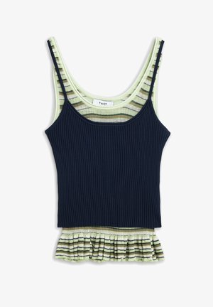 Twee gelaagde mouwloze tops: een marineblauwe geribbelde camisole over een lichtgroene top met bruine en beige strepen en een gerimpelde zoom.