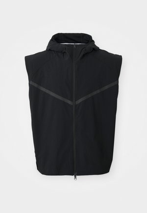 Gilet sans manches noir avec capuche. Possède une fermeture éclair à l'avant et des bandes réfléchissantes sur la poitrine. Fabriqué en tissu léger.