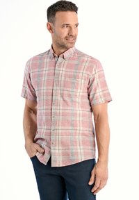 Korte mouwen, button-up shirt in rood en beige ruitpatroon, met een borstzakje, zachte stof en een relaxte pasvorm. Gekozen in combinatie met donkerblauwe jeans.