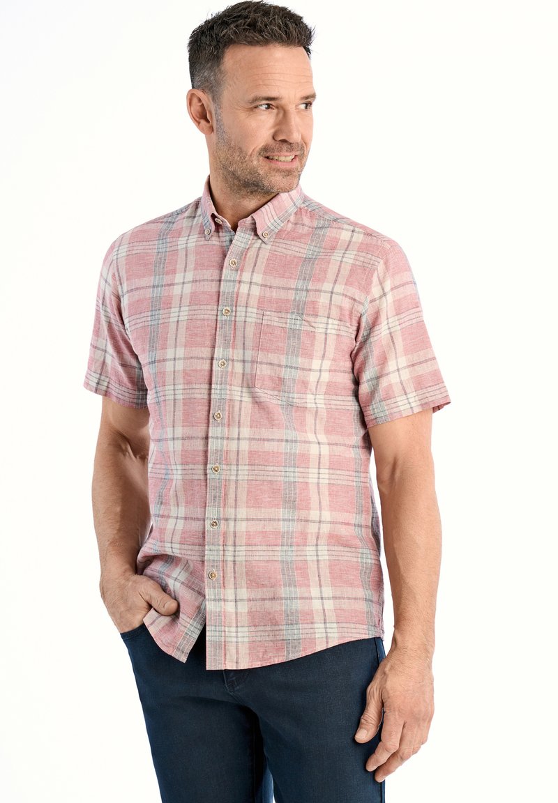 Korte mouwen, button-up shirt in rood en beige ruitpatroon, met een borstzakje, zachte stof en een relaxte pasvorm. Gekozen in combinatie met donkerblauwe jeans.