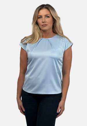 Light blue, short-sleeved blouse made of smooth fabric, featuring a pleated neckline and a relaxed fit, paired with dark jeans.