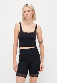 Black cropped tank top with lace trim and matching high-waisted shorts featuring lace accents at the hem, made from stretchy material.