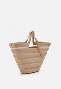 Oljetorebag med beigemøbler, med horisontale striper og bred åpning. Myk tekstur, romslig design og robuste håndtak.