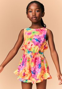 Tuta corta floreale colorata con vivaci tonalità di rosa, arancione, verde e blu. Vita elastica e dettagli con orlo arricciato valorizzano il design.