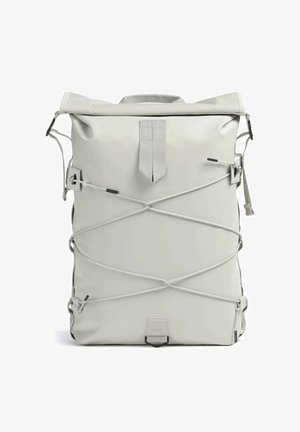 Zaino grigio chiaro con chiusura a risvolto, cordini regolabili incrociati sulla parte anteriore e una piccola toppa rettangolare con logo al centro in basso.