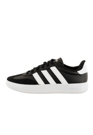 Sneaker bianco e nero con tomaia sintetica, caratterizzate da tre strisce bianche di lato, una punta in suede nero testurizzato e una suola in gomma bianca.