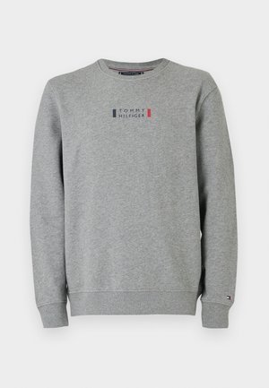 Sudadera gris de cuello redondo con el logo de "Tommy Hilfiger" en navy y rojo centrado en el pecho y pequeño logo de la bandera en el puño izquierdo.