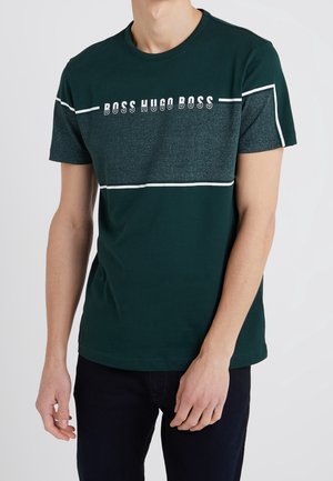 Grünes T-Shirt mit einer strukturierten dunkelgrünen horizontalen Streifen, weißen Akzentlinien und dem Aufdruck "BOSS HUGO BOSS" in Weiß auf der Brust.