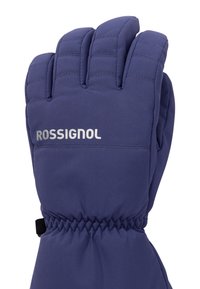 Mörkblå vadderad skidhandske med en åtdragen handled. Har en texturerad yta och en reflekterande "ROSSIGNOL"-logotyp på manschetten.