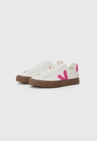 Hvite lær sneakers med rosa "V"-logo, brun gummisåle og snøring. Teksturert overflate og forsterket tåområde.