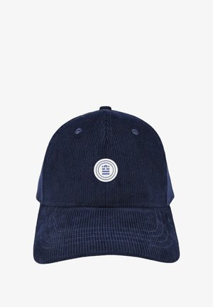 Casquette en velours côtelé bleu marine avec une couronne arrondie, une visière courbée et un logo blanc circulaire à l'avant. Tissu texturé avec des rayures verticales.