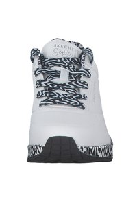 Baskets Skechers blanches avec des lacets et une semelle à motifs noir et blanc, vues de face.